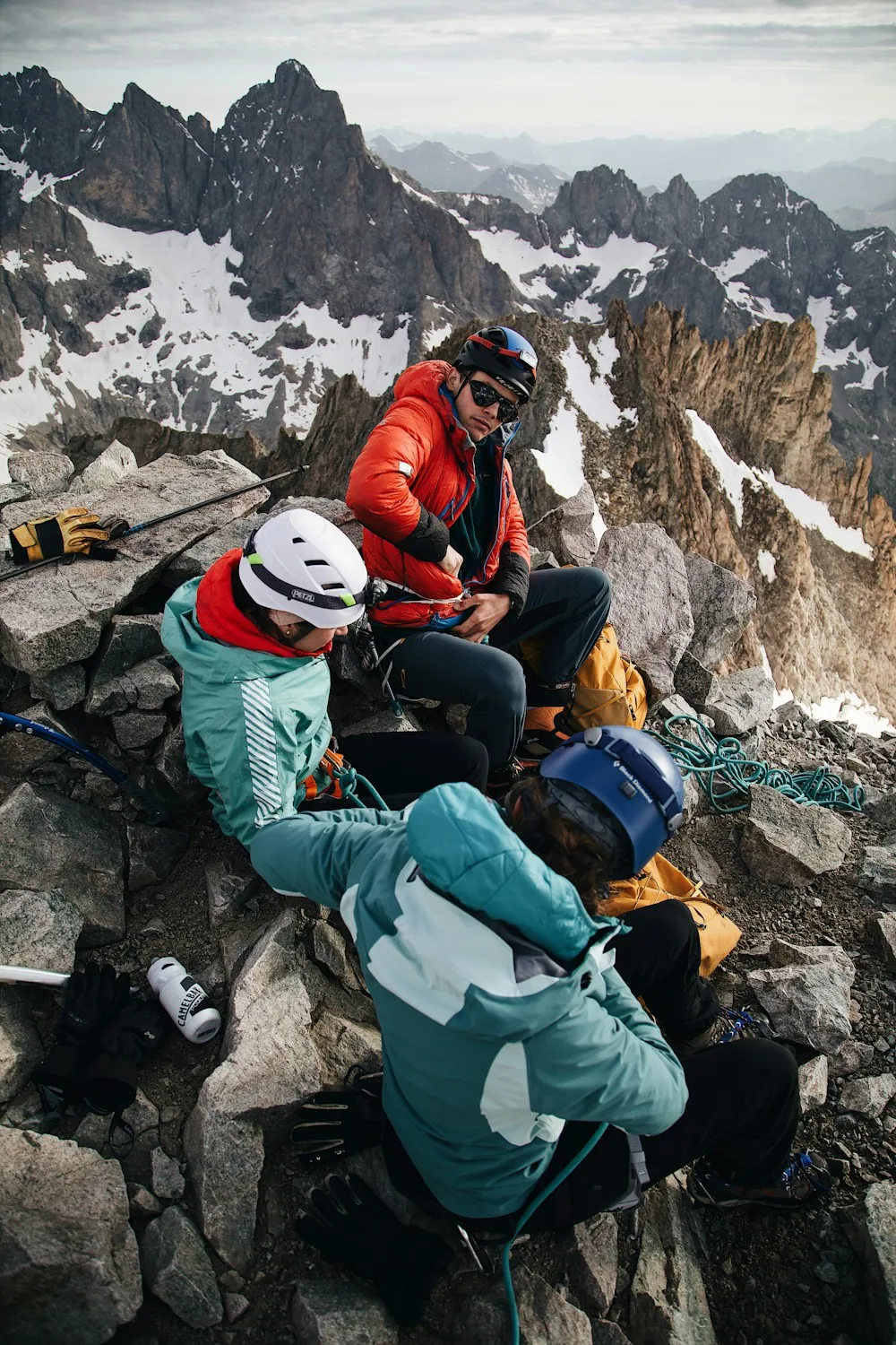 Climbers in helmets resting together on a rocky mountain slope